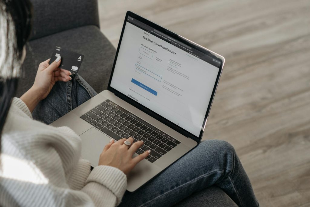 a person using her laptop while holding a credit card
